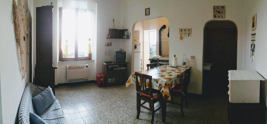 a living room with a table and a kitchen at La casa del golfo in Gavorrano