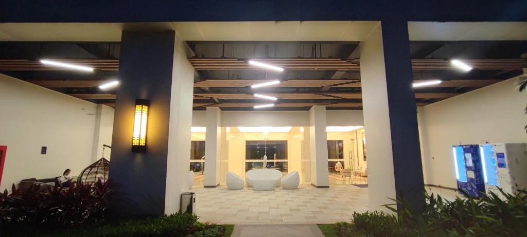 a lobby of a building with white chairs and lights at BSDE 2BR Skyhouse Jervois in Cilenggang