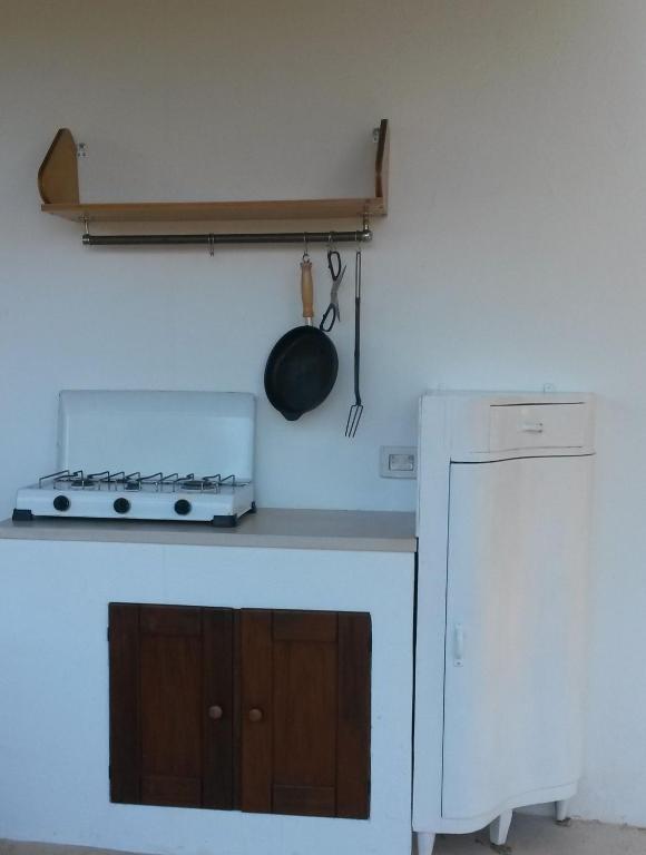 a kitchen with a stove and a pan on the wall at Case d'Artista in Savelletri di Fasano