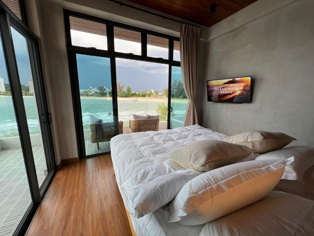 a bedroom with a bed with a view of the ocean at Ocean Nadi 4 Bedrooms Beachfront Villa PD in Port Dickson