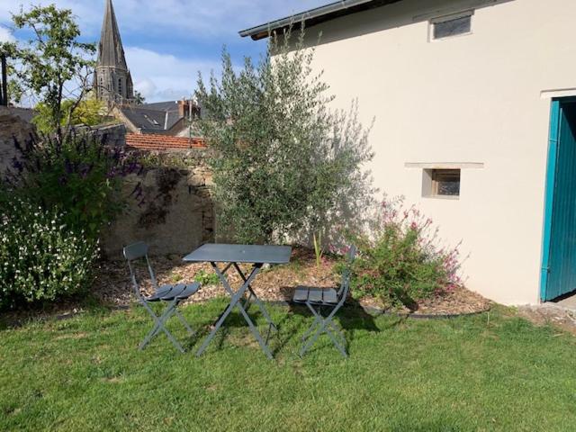a picnic table and two chairs in a yard at Chambre d'Hôtes Les Petits Oiseaux in Nantes