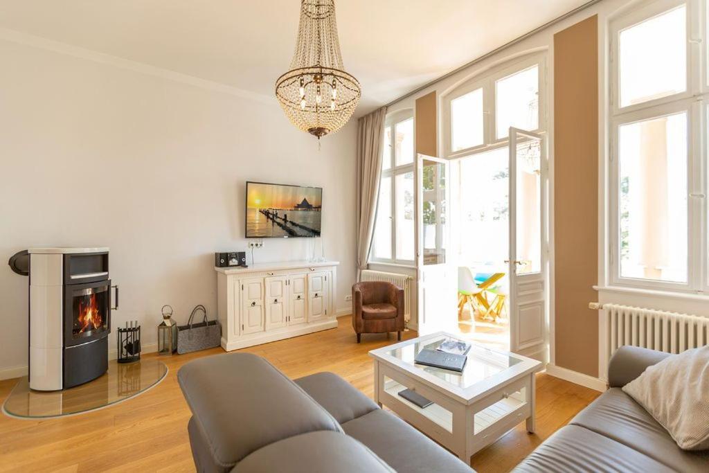 uma sala de estar com um sofá e uma lareira em Villa Saphira App 09 em Heringsdorf