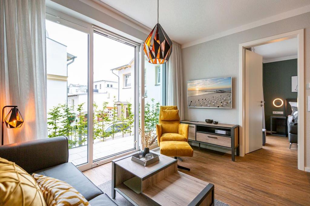 a living room with a couch and a large window at Quartier Frohsinn App 02 in Ahlbeck