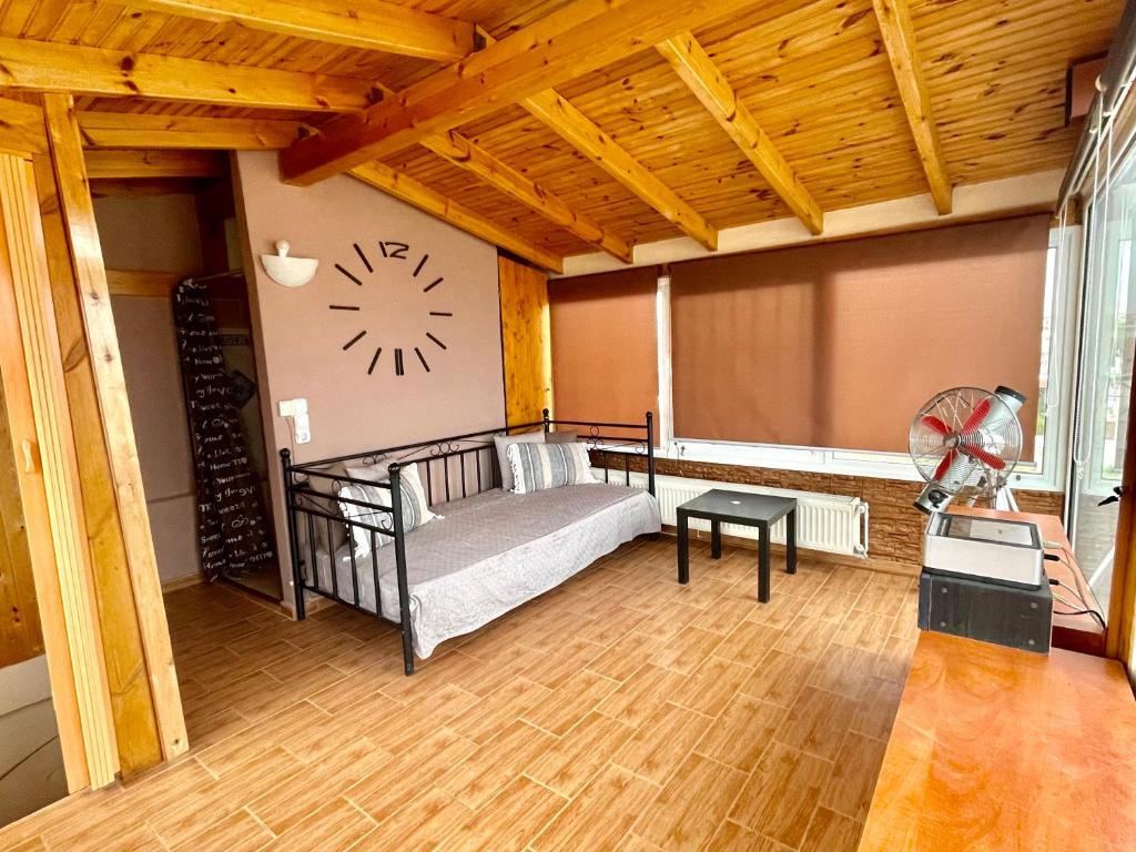 a room with a bed and a clock on the wall at Villa AMIA in Áyios Spirídhon