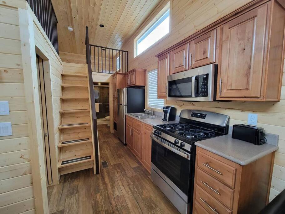 a kitchen with wooden cabinets and a stove and microwave at 036 Tiny Home nr Grand Canyon South Rim Sleeps 8 in Valle