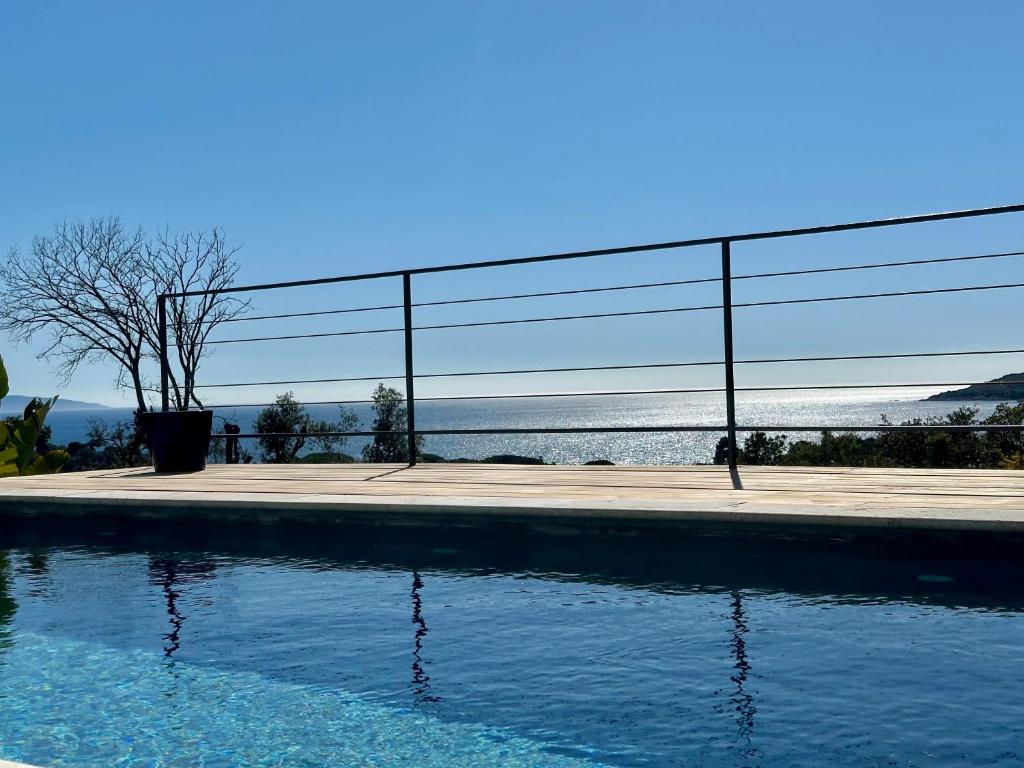 a pool of water with a fence next to it at Villas de standing avec magnifique vue mer et piscines privées, Sagone in Sagone