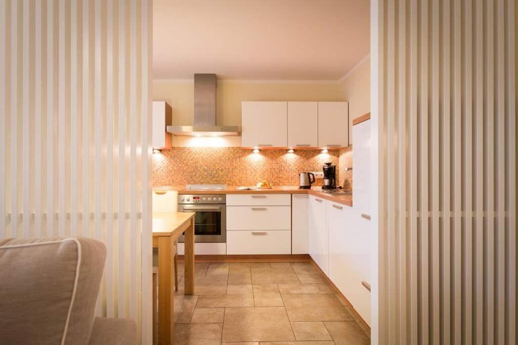 eine kleine Küche mit weißen Schränken und einem Tisch in der Unterkunft Quartier 47, App. 07 in Bansin