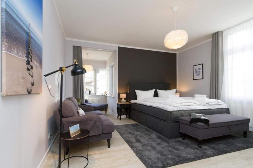 Un dormitorio con una cama, un sofá y una silla. en Villa Brunnenstraße, App 1, en Heringsdorf