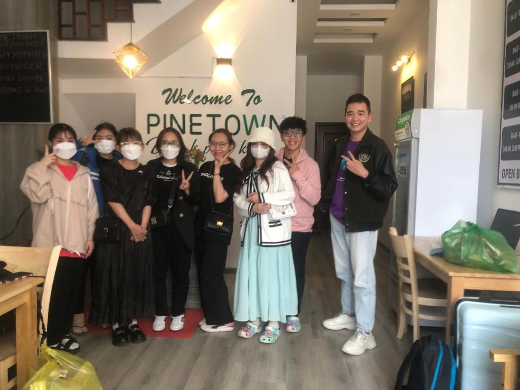 Un groupe de personnes debout dans une pièce avec des masques sur le visage dans l'établissement PINETOWN Homestay, à Đà Lạt