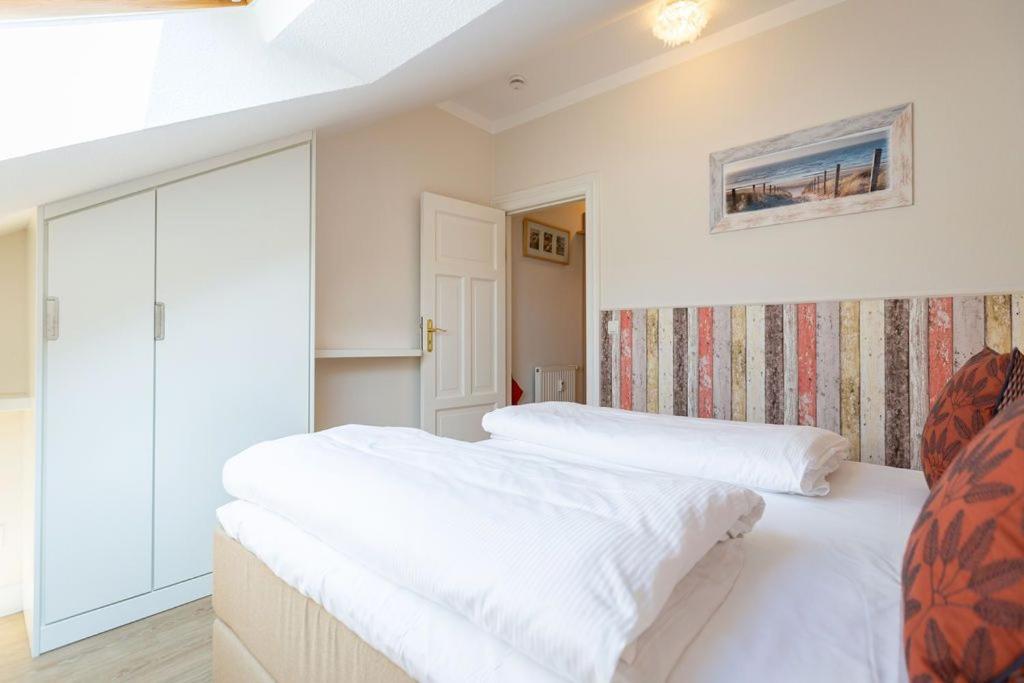 2 bedden in een kamer met witte lakens bij Villa Linquenda App 6 in Ahlbeck