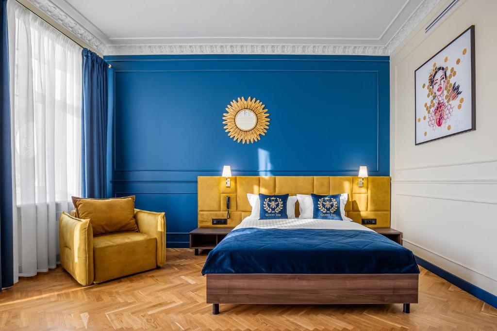 1 dormitorio azul con 1 cama y 1 silla en Queen Bee en Kiev