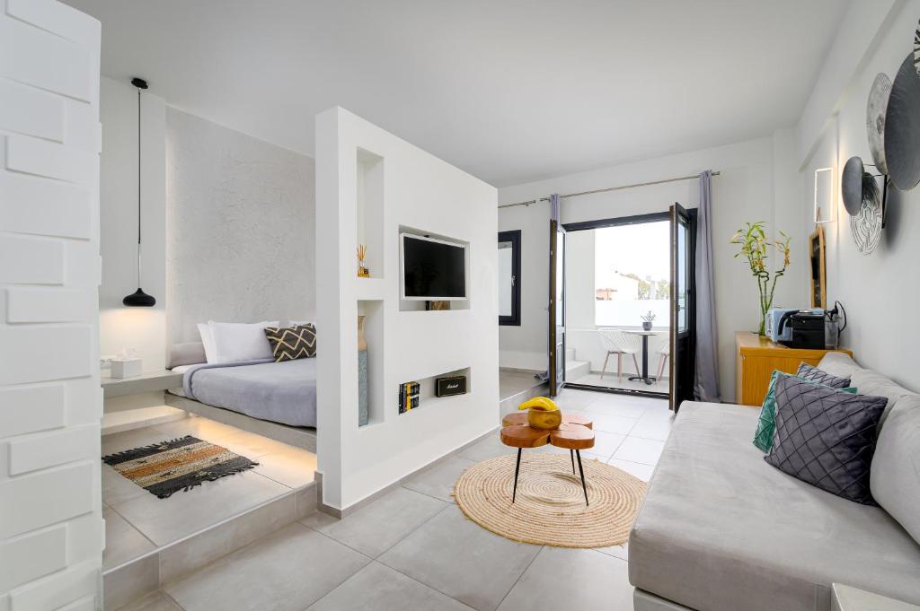 George & Joanna Suites Santorini في فيرا: غرفة معيشة مع أريكة وتلفزيون