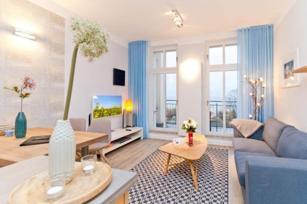 uma sala de estar com um sofá azul e uma televisão em Villa Anna, App 12 em Ahlbeck