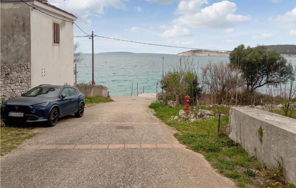 a car parked on the side of a road near the water at 1 Bedroom Awesome Apartment In Martinscica in Martinšćica