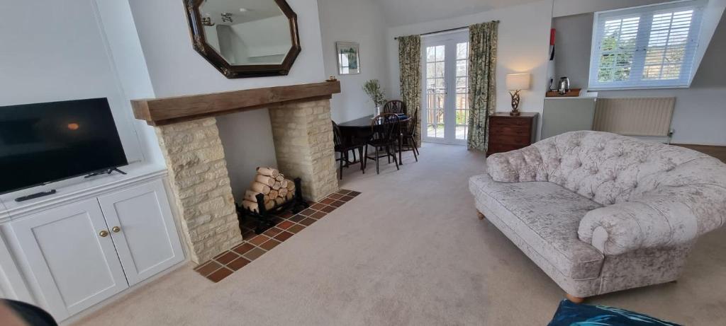 a living room with a couch and a fireplace at Yew Tree House in Woodstock