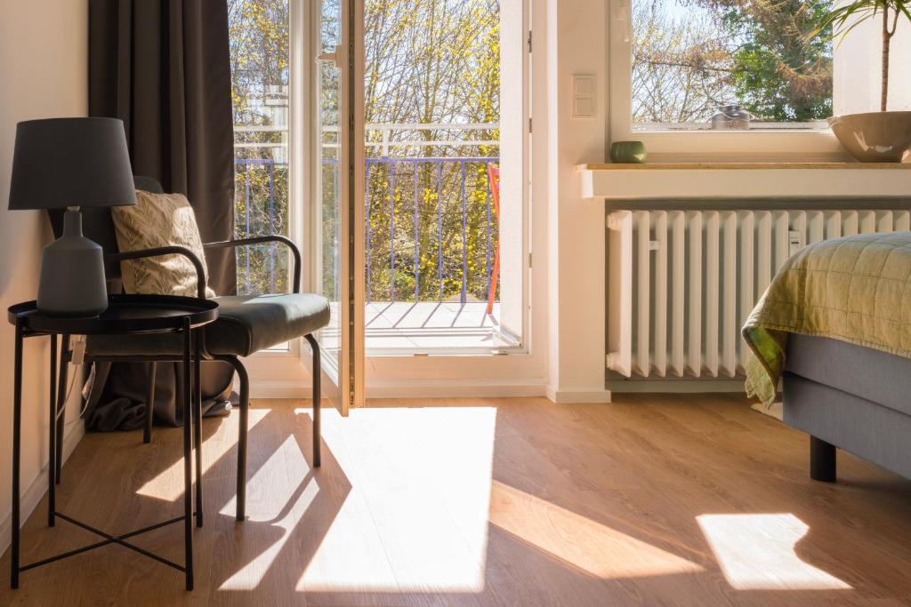 a bedroom with a bed and a chair and a window at FeelsLikeHome - Traumhafte zentrumsnahe Wohnung mit Balkon&Parkplatz in Bochum