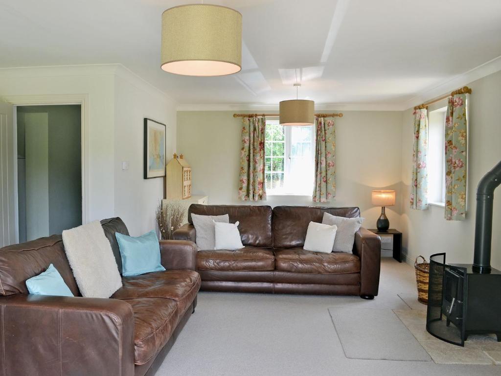 a living room with a brown leather couch at Barrowswood in Cheddar