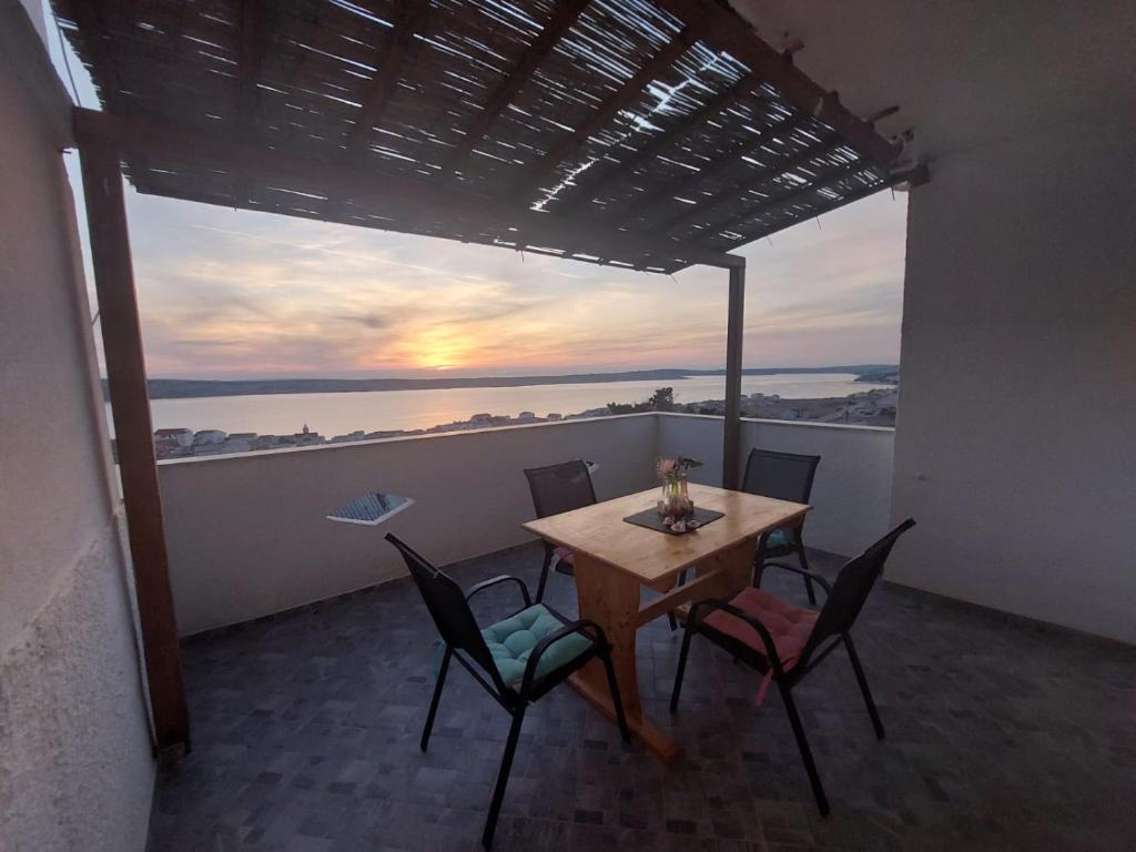 a table and chairs on a balcony with a view of the ocean at Apartmani Orešković in Kustići