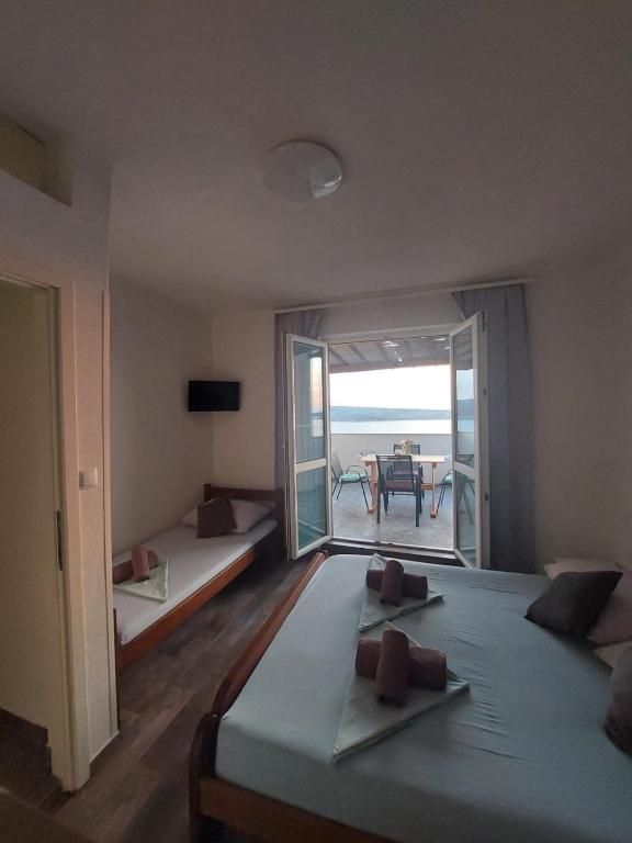 a bedroom with two beds and a view of the ocean at Apartmani Orešković in Kustići