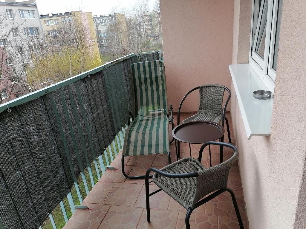 two chairs and a table on a balcony at Apartament Arena in Zgorzelec