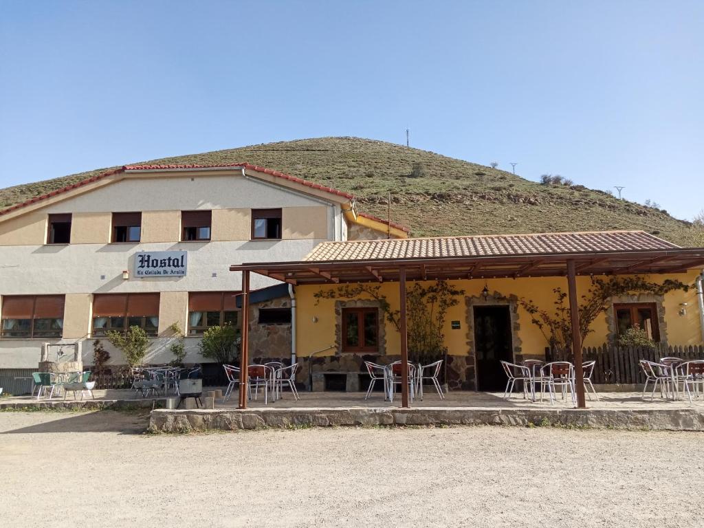 a restaurant with tables and chairs in front of a building at Hostal La Collada de Aralla in Aralla de Luna