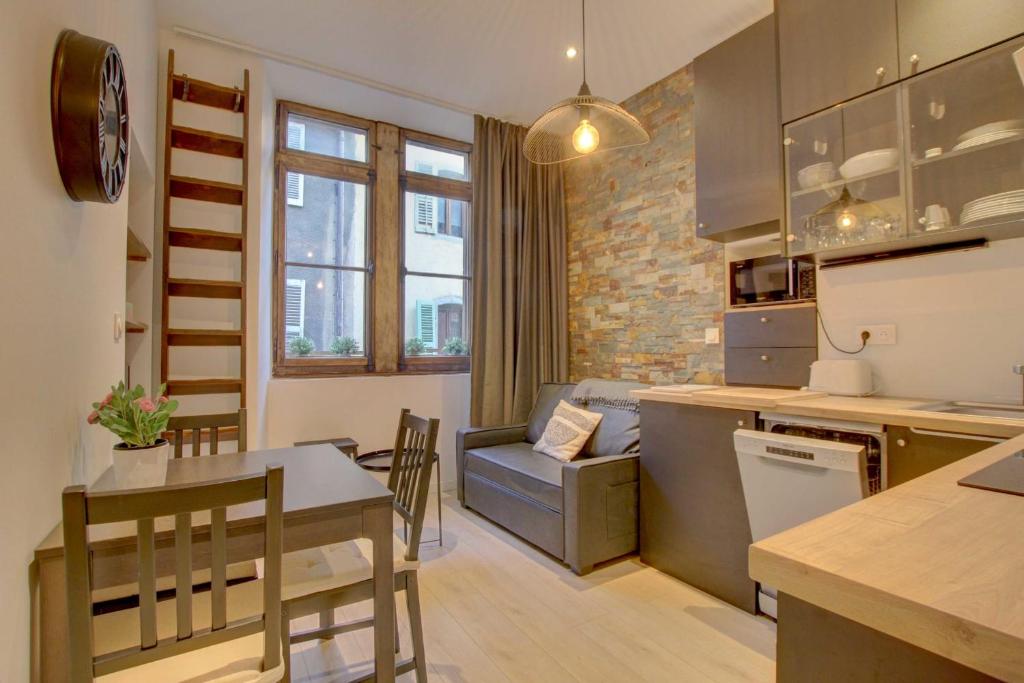 a kitchen and living room with a table and a dining room at Le Rousseau - Beautiful studio in Old Town in Annecy