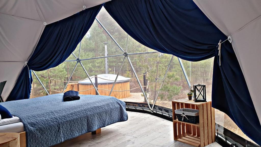 um quarto com uma cama numa tenda em Podniebny Glamping em Borsk
