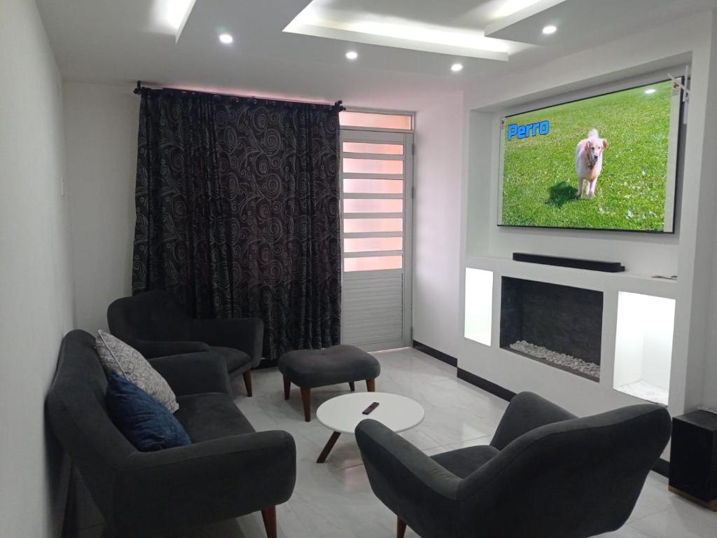 sala de estar con sillas y TV en la pared en New comfortable house at Paipa close to everything great location, en Paipa