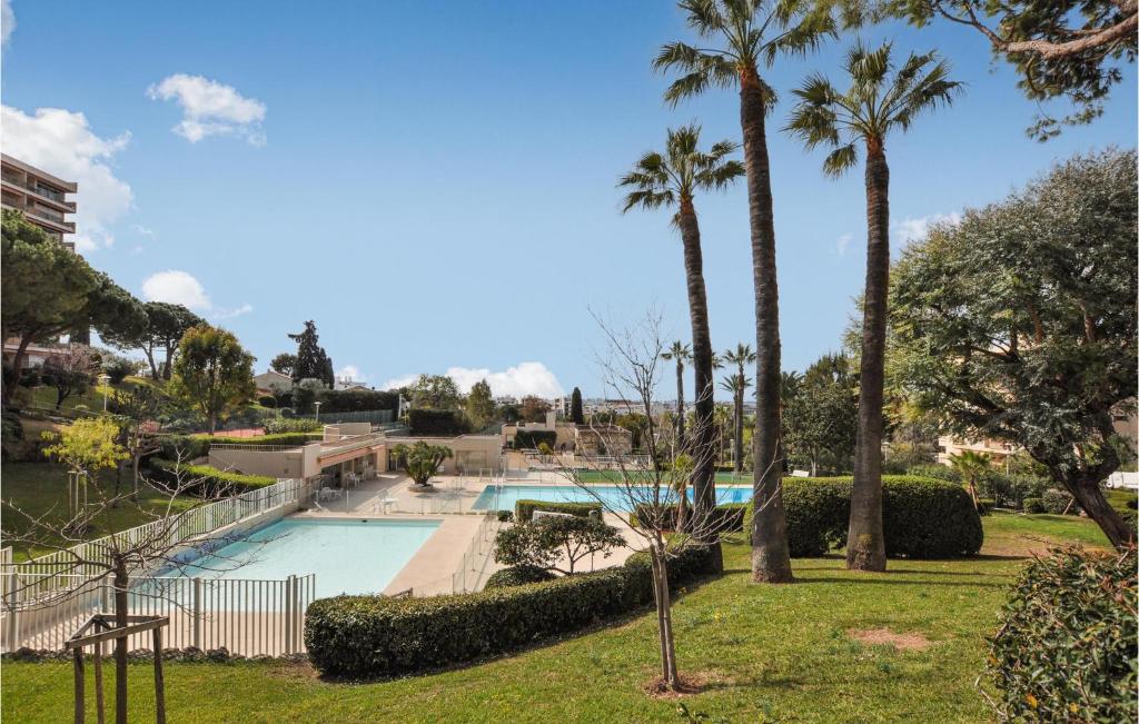 une piscine entourée de palmiers dans un parc dans l'établissement 1 Bedroom Amazing Apartment In Antibes, à Antibes
