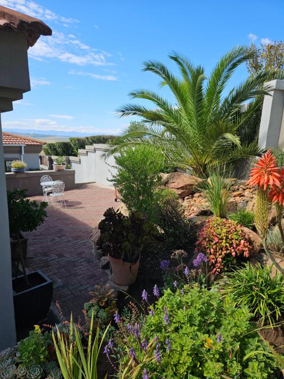 Three Stones Executive Apartments في ماسيرو: حديقة بها الزهور والنباتات على المنزل