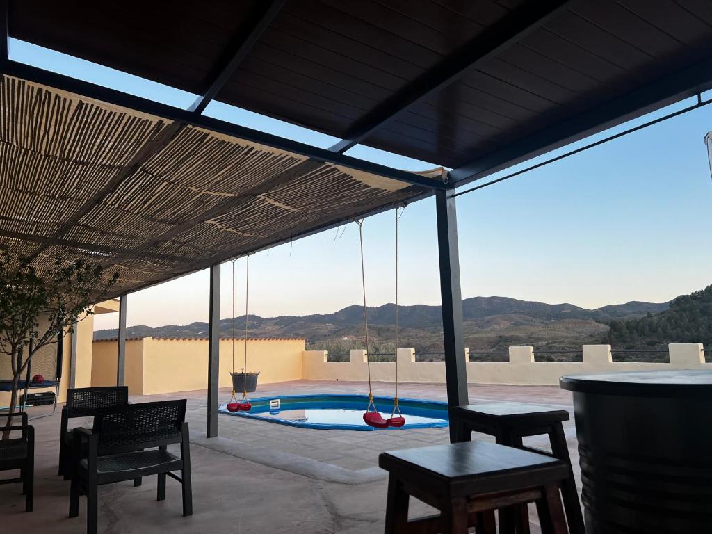 eine Terrasse mit Stühlen und einem Pool mit Aussicht in der Unterkunft Cortijo Alba in Vélez-Blanco