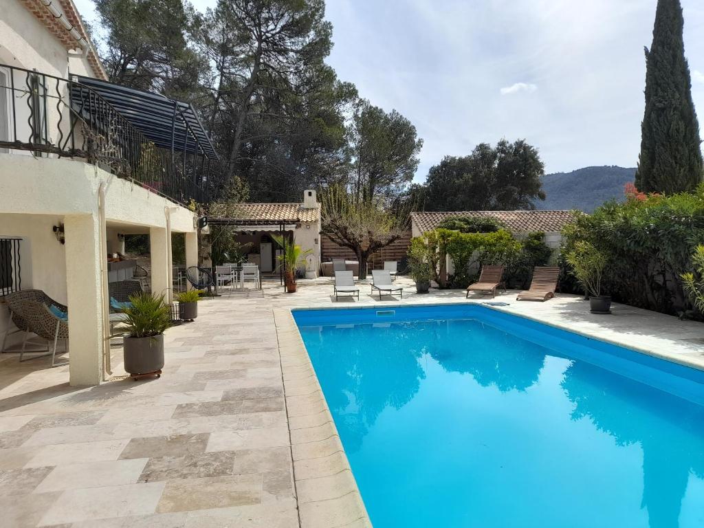 une piscine dans la cour d'une maison dans l'établissement les arbousiers brignoles piscine et spa, à Brignoles