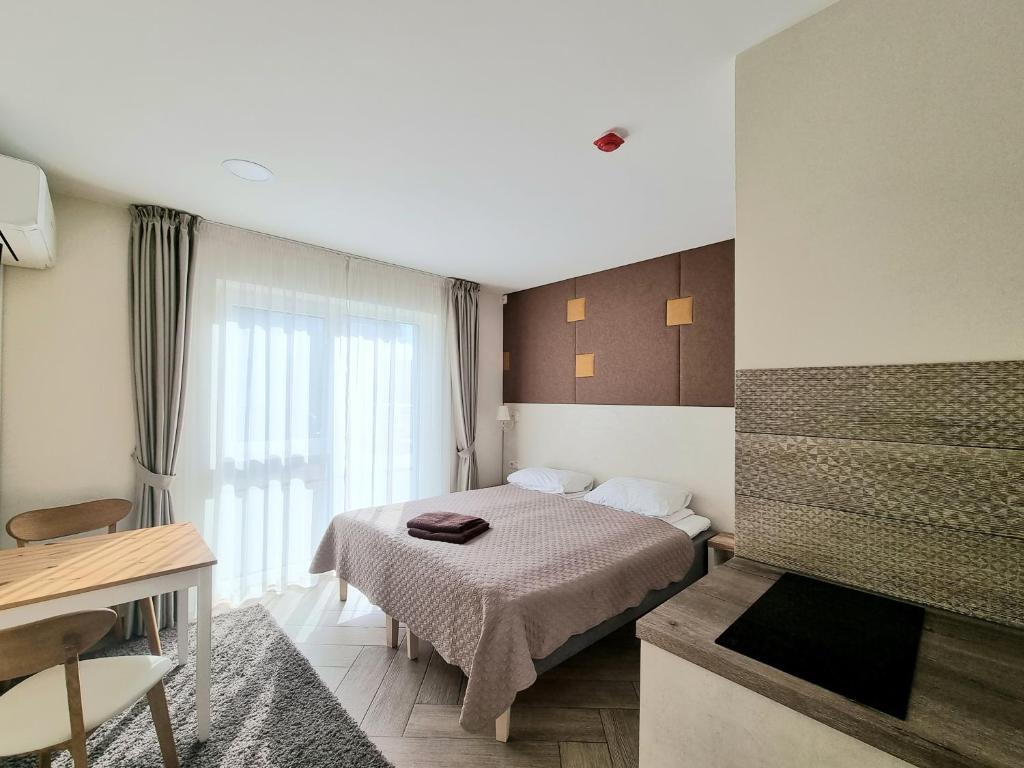 a hotel room with a bed and a television at Amber Drop apartments in Palanga
