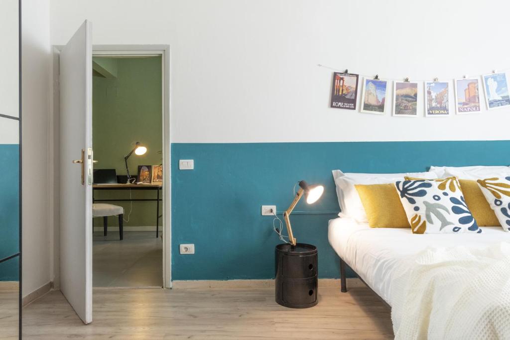 um quarto com uma cama branca e uma parede azul em Aeroporto - Modern Apartment em Florença