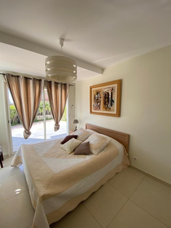 - une chambre avec un grand lit et une grande fenêtre dans l'établissement Villa Le week end, à Ajaccio