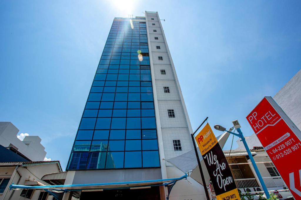 a tall building with the sun shining on it at PP Hotel by Moxy in George Town