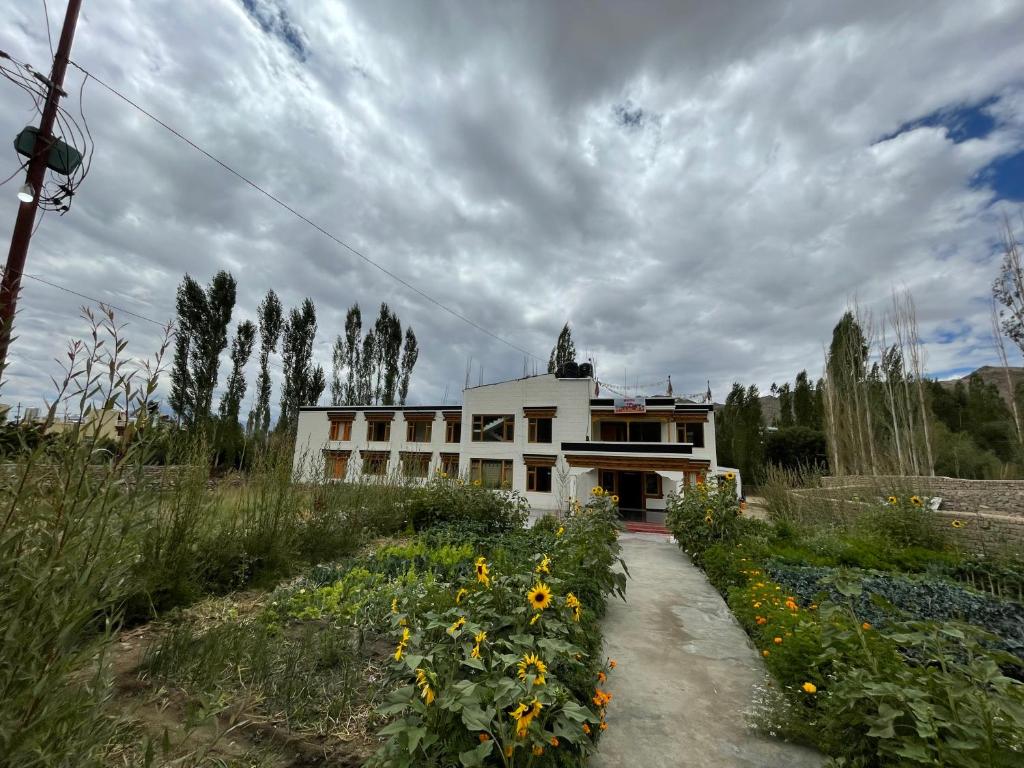 un edificio con un campo di girasoli davanti di Hotel DZI Ladakh a Leh