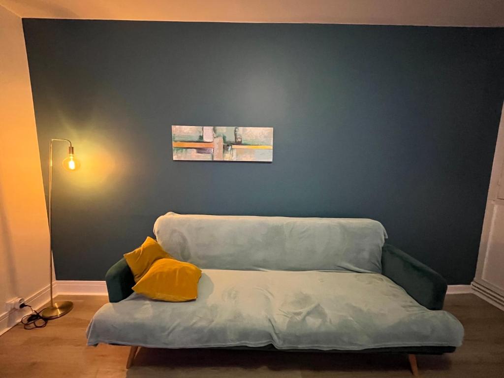 a couch with two pillows on it in a room at Appartement Prestige - Amiens in Amiens