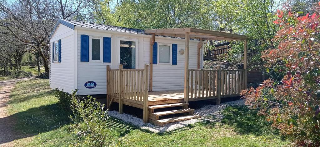 a tiny house with a porch and a gazebo at CAMPING LE BEL AIR- Mobil home le laurier in Limogne-en-Quercy