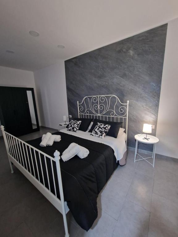 a bedroom with a black and white bed and a table at Black & white in Catania