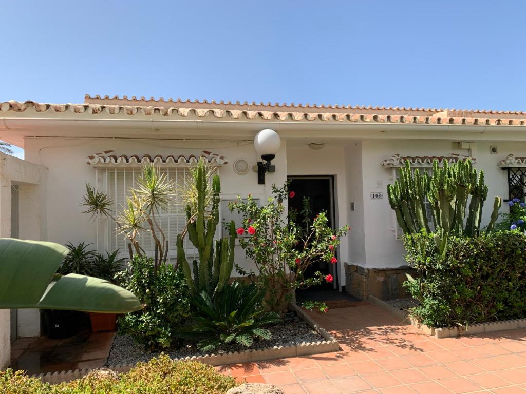 una casa con muchas plantas delante de ella en Beach Bungalow, en Málaga