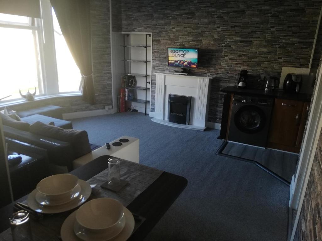 a living room with a couch and a fireplace at Moorburn Heights in Largs