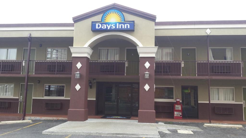 een groot gebouw met een dagherbergbord erop bij Days Inn by Wyndham Hot Springs in Hot Springs