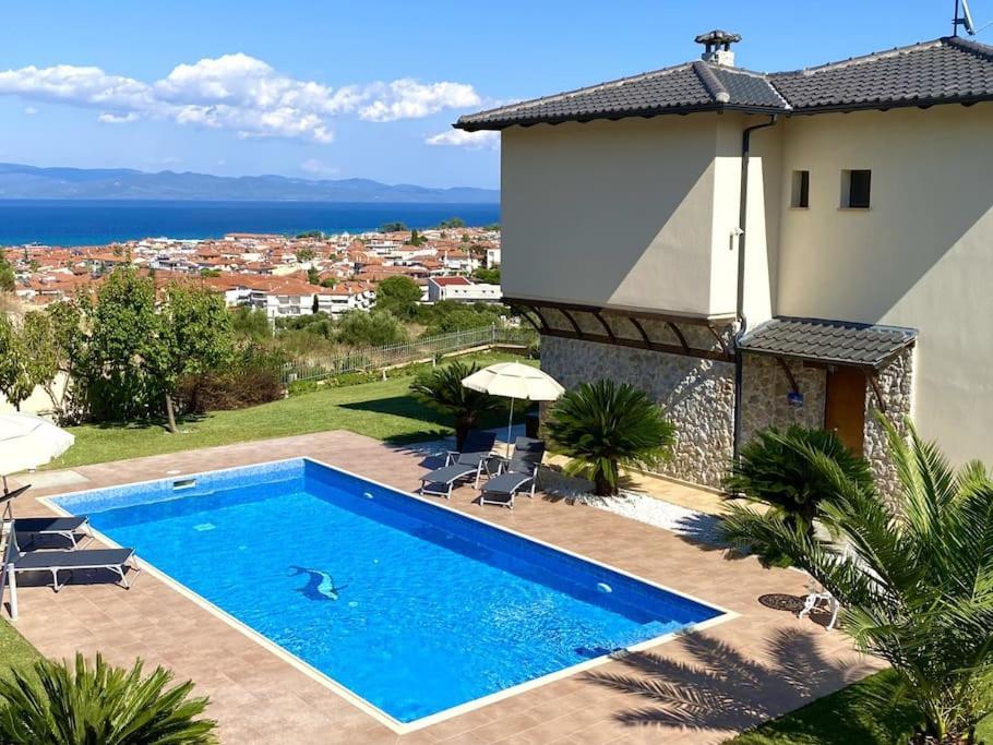 a swimming pool in front of a house at Villa Oceanview Vicky in Pefkochori