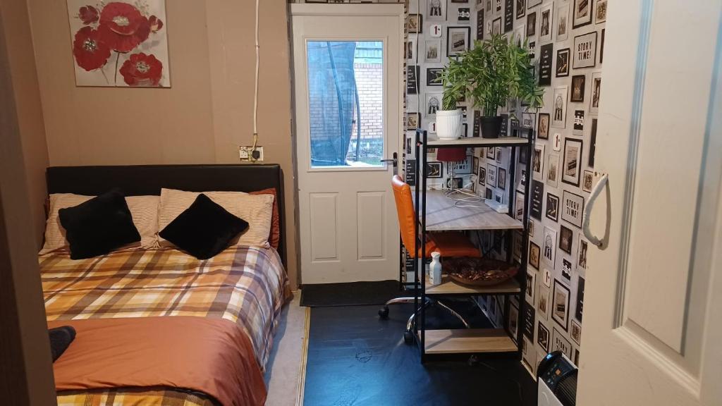 a bedroom with a bed and a wall with pictures at Double Bedroom in converted garage-No shower,bath facility in Bristol