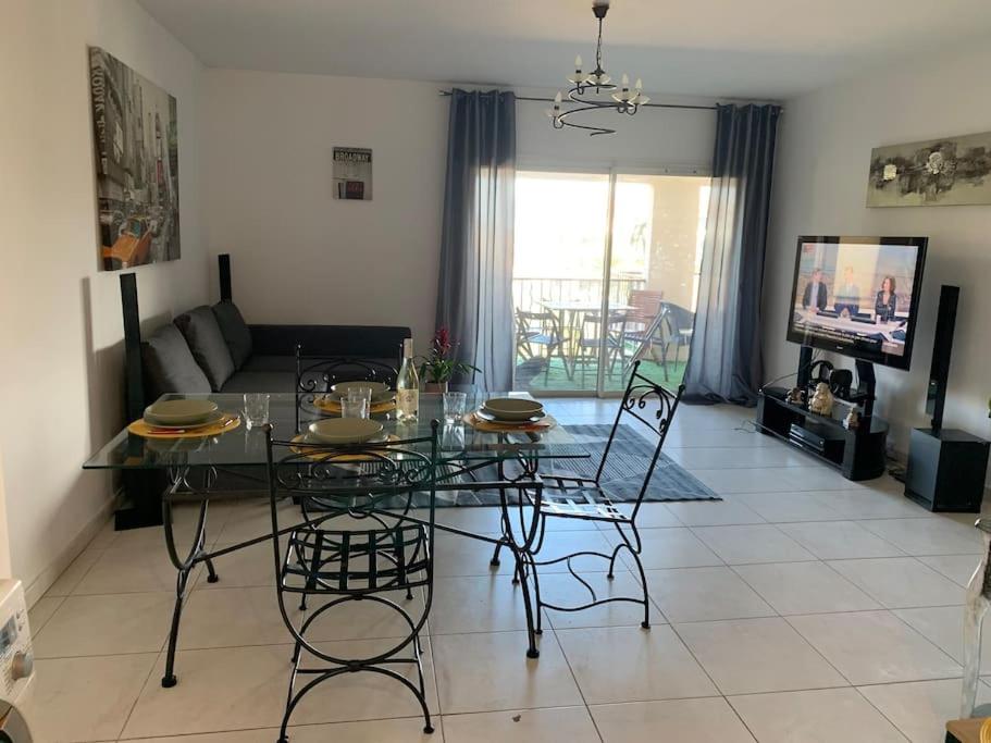 sala de estar con mesa de cristal y sillas en Bel appartement à 100 m du port, en Porto Vecchio