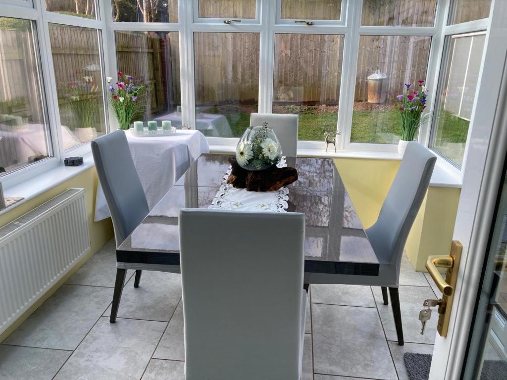 a dining room table with chairs and a vase on it at Holiday Home in Cardiff which sleep 5 and we try and make it a home from home in Cardiff