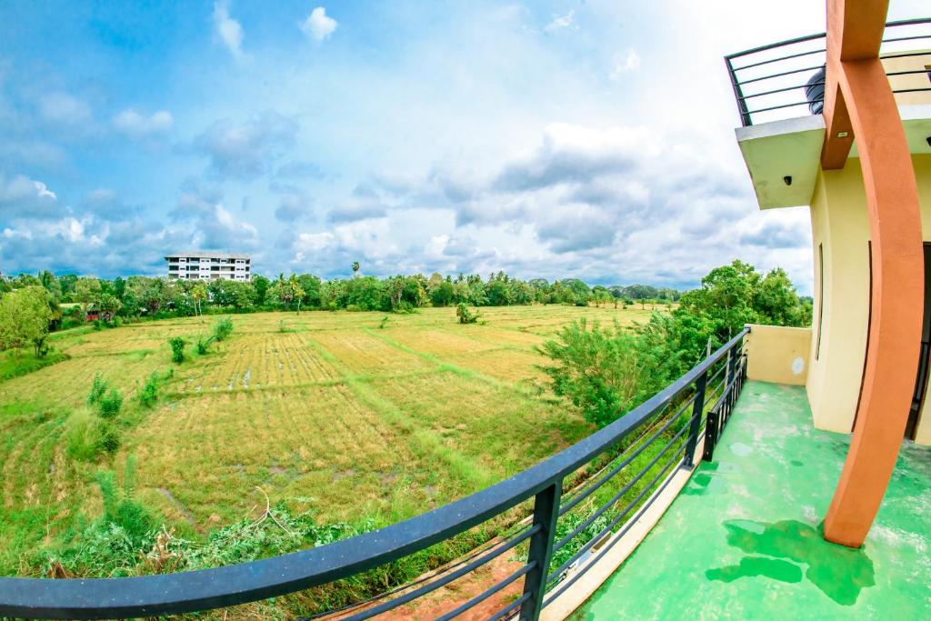 a balcony with a view of a field at Aspirations Holiday Villas in Anuradhapura