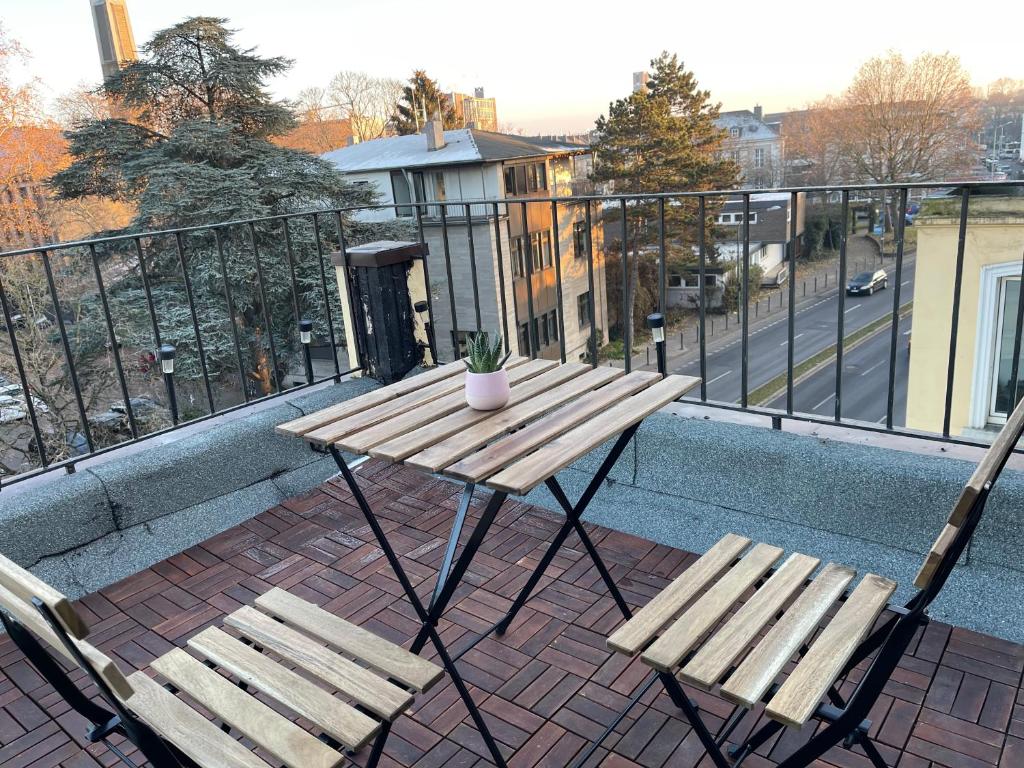 einen Holztisch und zwei Stühle auf dem Balkon in der Unterkunft Leon Duren in Düren - Eifel