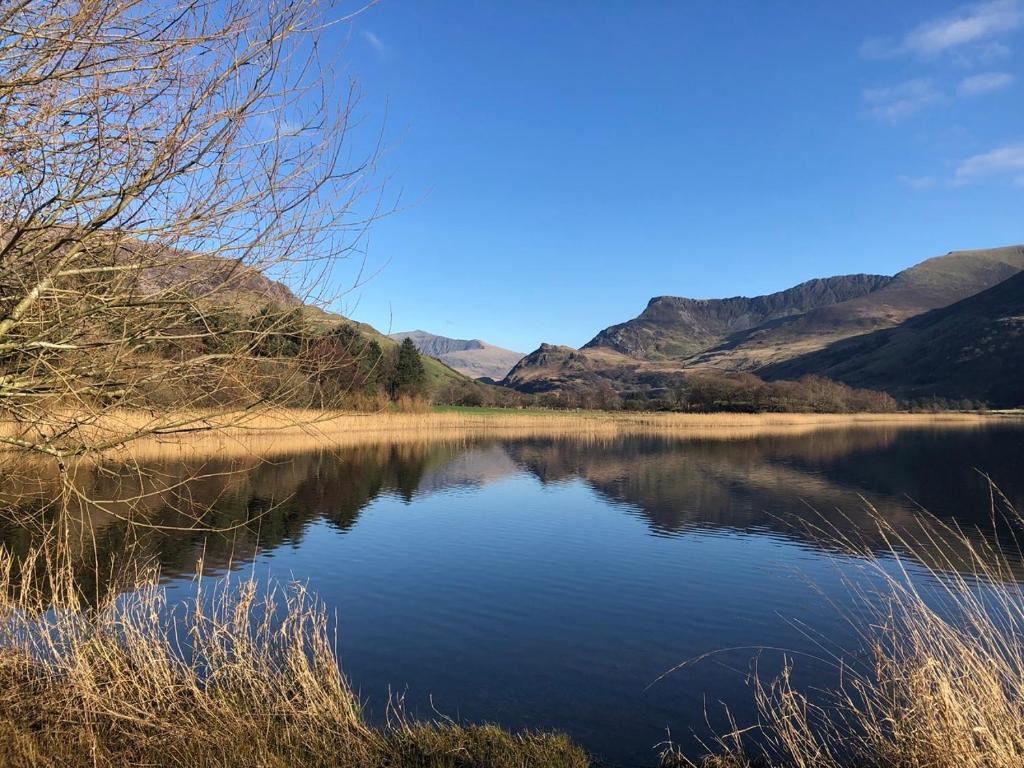 a view of a lake with mountains in the background at Trigonos - Peaceful Lakeside Vegetarian B&B and Retreat in Eryri National Park in Caernarfon